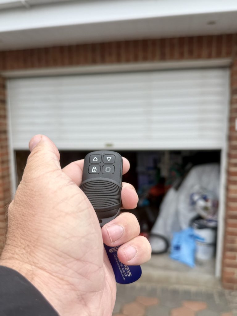 Locksmith Kev programming a replacement garage door remote for an obsolete roller shutter garage door system in Wallsend, Tyne and Wear.