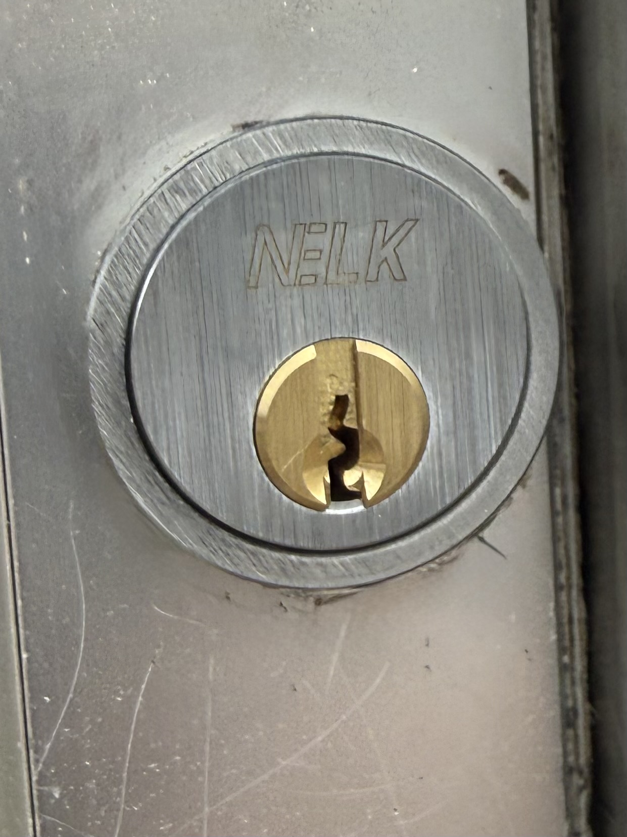NELK high-security euro cylinder installed in a commercial aluminium door at a retail premises.